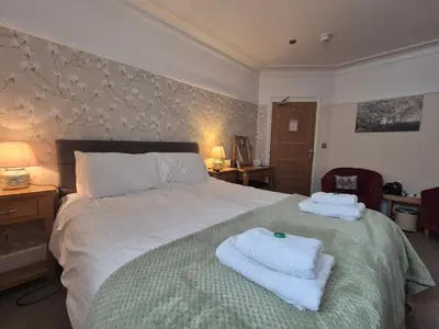 a bedroom with a bed with towels on it at Tregarth House in St Austell