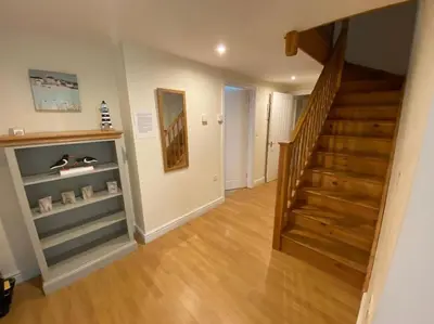 a hallway with a staircase and a stair case at Karrek View - Trebarwith Strand (Sleeps 8-10) in Treknow