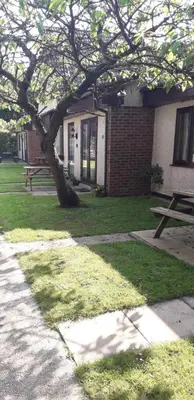 a picnic table and a tree in front of a building at 11 Trevithick Court Tolroy Manor in Hayle