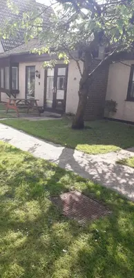 a house with a tree and a picnic table in a yard at 11 Trevithick Court Tolroy Manor in Hayle