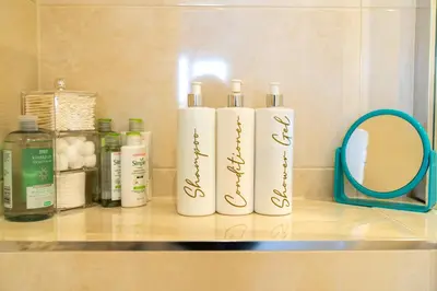 three bottles ofodorizers sitting on a shelf next to a mirror at Trethvor House FREE PARKING, Ensuite Double Quiet residential area in Padstow