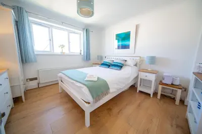 a bedroom with a bed with blue pillows on it at Trethvor House FREE PARKING, Ensuite Double Quiet residential area in Padstow