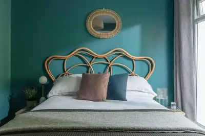 a bedroom with a bed with blue walls and a mirror at Number 4 - Stylish 1 bedroom house in Truro, Cornwall in Truro