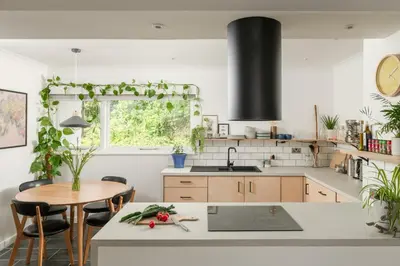 a kitchen with white counters and a table with chairs at Number 4 - Stylish 1 bedroom house in Truro, Cornwall in Truro
