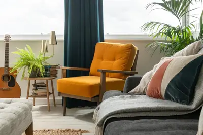 a living room with an orange chair and a guitar at Number 4 - Stylish 1 bedroom house in Truro, Cornwall in Truro