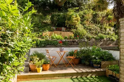 a garden with a table and chairs and plants at Number 4 - Stylish 1 bedroom house in Truro, Cornwall in Truro