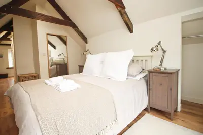 a bedroom with a large white bed with white pillows at Town centre apartment with parking in Padstow