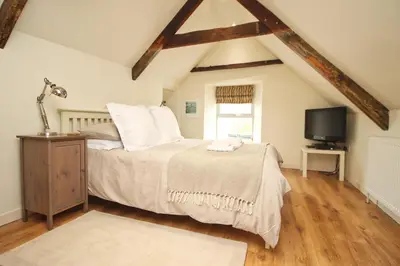 a bedroom with a bed and a tv in it at Town centre apartment with parking in Padstow