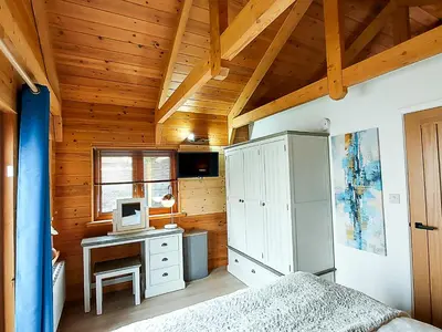 a bedroom with a bed and a desk with a computer at Meadow View Apartments in Newquay