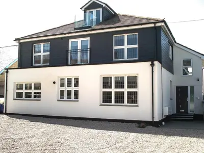 a white and black house with a lot of windows at Meadow View Apartments in Newquay