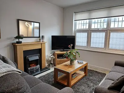 a living room with a fireplace and a television at Meadow View Apartments in Newquay