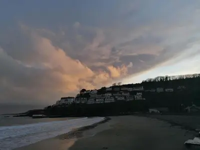 a group of houses on a hill next to the beach at Schooner Point Guest House in Looe
