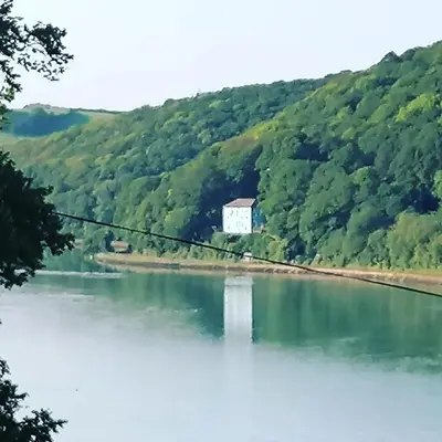a view of a lake with a white building in the middle at Schooner Point Guest House in Looe