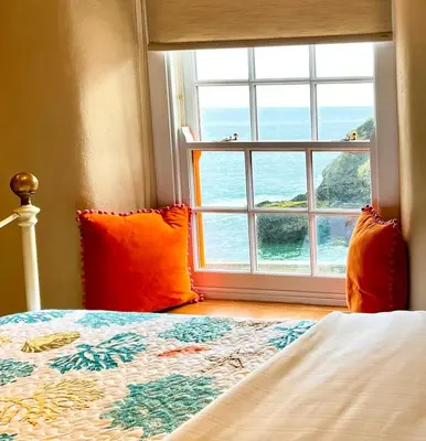 a bedroom with a bed and a large window at Just Opened. Romantic Clifftop Retreat in Portloe