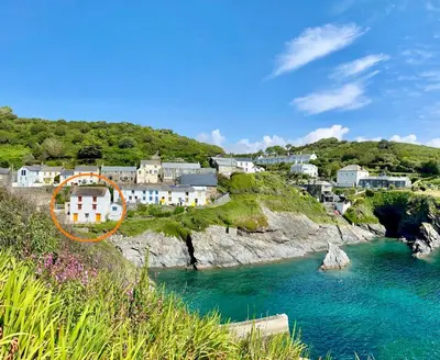 a house on a cliff next to a body of water at Just Opened. Romantic Clifftop Retreat in Portloe
