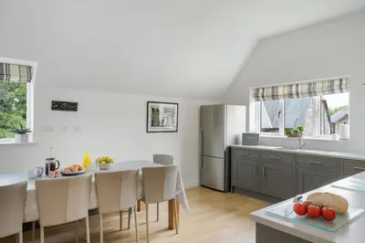 a kitchen and dining room with a table and chairs at The Hawthorns in Polzeath