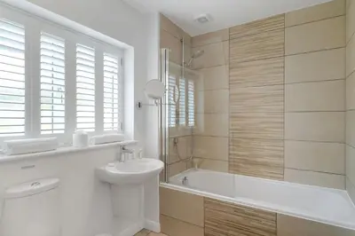 a bathroom with a tub and a sink and a toilet at The Hawthorns in Polzeath