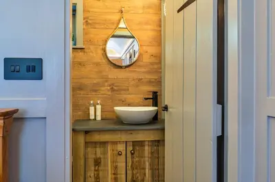 a bathroom with a sink and a mirror at Finest Retreats - Driftwood in Poundstock