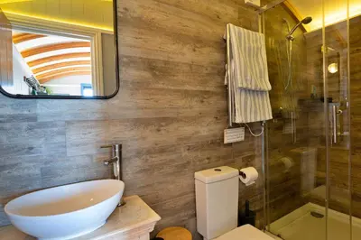 a bathroom with a sink and a toilet and a mirror at Finest Retreats - Driftwood in Poundstock