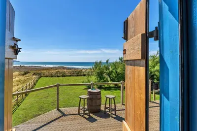 a door to a deck with a view of the ocean at Finest Retreats - Driftwood in Poundstock