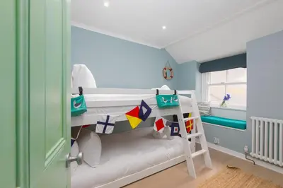 a small room with a bunk bed and a ladder at Puffin Cottage in St Ives