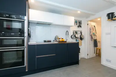 a kitchen with black and white appliances at Puffin Cottage in St Ives