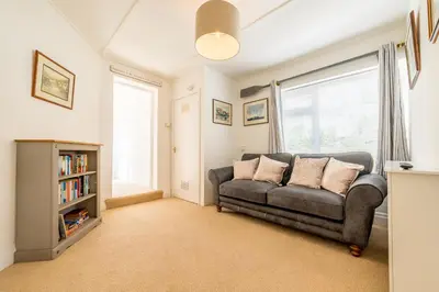 a living room with a couch and a window at The Decker Apartment in Looe
