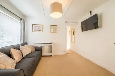 a living room with a couch and a tv at The Decker Apartment in Looe