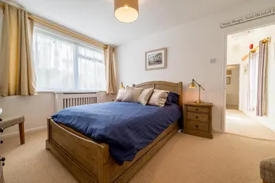a bedroom with a large bed and a window at The Decker Apartment in Looe