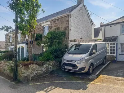 a van parked in a parking lot in front of a house at Churchtown Cottage in Cubert