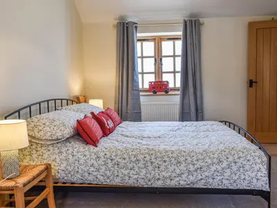 a bedroom with a bed with red pillows on it at The Potting Shed in Par