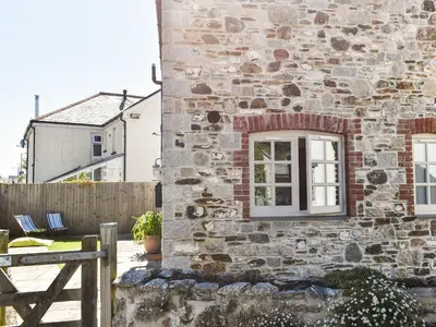 a stone building with a window and a fence at The Potting Shed in Par