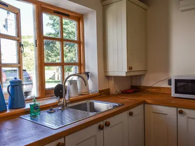 a kitchen counter with a sink and a window at The Potting Shed in Par