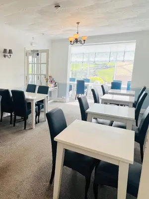 a waiting room with white tables and chairs at Tremarne Hotel in Mevagissey