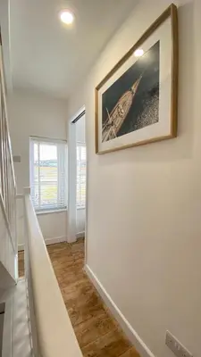 a hallway with a picture of a boat on the wall at SMUGGLERS HIDE or SMUGGLERS CABIN - EITHER a 2 Bedroom FISHERMANS COTTAGE with Childs Bunk and HARBOUR VIEWS - OR a ground floor private small CABIN ROOM - 10 Metres To Sea Front - Book Both for a 3 Bed House - 2023 GLOBAL REFURBISHMENT AWARD WINNER in St Ives