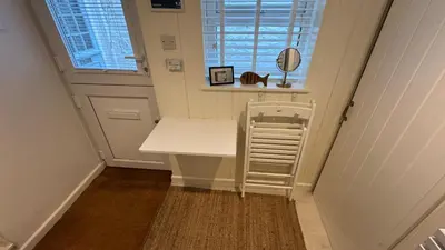 a small room with a white table and a window at SMUGGLERS HIDE or SMUGGLERS CABIN - EITHER a 2 Bedroom FISHERMANS COTTAGE with Childs Bunk and HARBOUR VIEWS - OR a ground floor private small CABIN ROOM - 10 Metres To Sea Front - Book Both for a 3 Bed House - 2023 GLOBAL REFURBISHMENT AWARD WINNER in St Ives