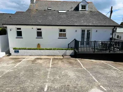 a white house with a parking lot in front of it at Room 2 Hotel style Double bedroom in Marazion in Marazion