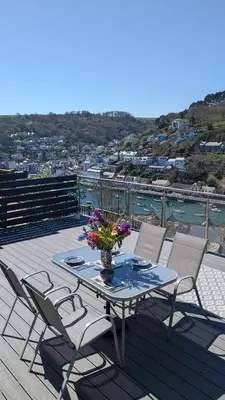 a table and chairs on a deck with a view of the water at The Hillocks, Looe - Two Bedroom House with Fabulous Views of Looe Town and Harbour in Looe