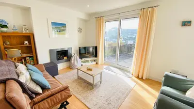 a living room with a couch and a large window at The Hillocks, Looe - Two Bedroom House with Fabulous Views of Looe Town and Harbour in Looe