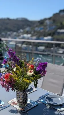 a vase filled with flowers sitting on a table at The Hillocks, Looe - Two Bedroom House with Fabulous Views of Looe Town and Harbour in Looe