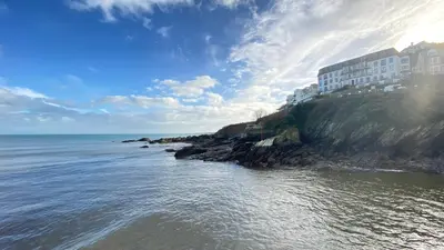 a building on a cliff next to the ocean at The Hillocks, Looe - Two Bedroom House with Fabulous Views of Looe Town and Harbour in Looe