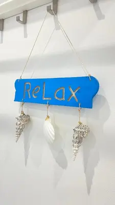a blue sign that says relax with a pair of seashells at The Hillocks, Looe - Two Bedroom House with Fabulous Views of Looe Town and Harbour in Looe