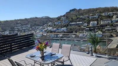 a table on a balcony with a view of the water at The Hillocks, Looe - Two Bedroom House with Fabulous Views of Looe Town and Harbour in Looe