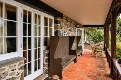 a porch with large windows and a bench at Finest Retreats - Tregatreath in Coverack