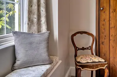 a pillow and a chair sitting next to a window at Finest Retreats - Tregatreath in Coverack