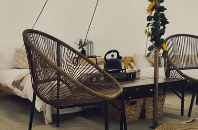 a room with a table with two chairs and a bed at Porthleven Glamping in Porthleven