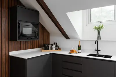 a kitchen with black cabinets and a black microwave at Luxury Modern Suite in Marazion with Parking in Marazion