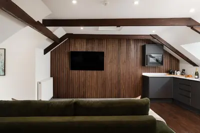 a living room with a couch and a kitchen at Luxury Modern Suite in Marazion with Parking in Marazion