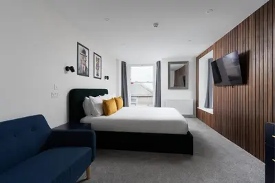 a bedroom with a bed and a couch and a tv at Room 3 Hotel style Double bedroom in Marazion in Marazion