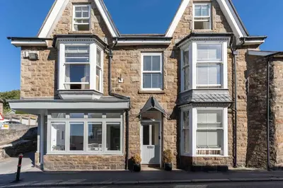 a brick house with white windows and a porch at Room 3 Hotel style Double bedroom in Marazion in Marazion